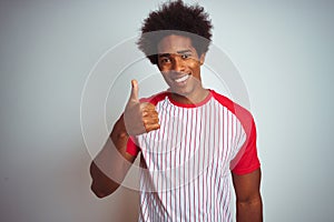 African american man with afro hair wearing red striped t-shirt over isolated white background doing happy thumbs up gesture with