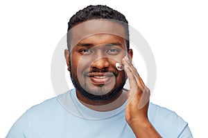 African american man applying moisturizer to face