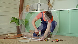 African American man assembling DIY furniture with electric drill screwdriver