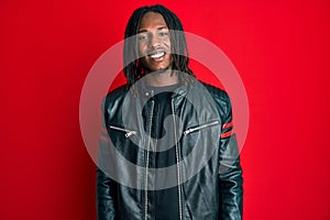 African american man with braids wearing black leather jacket with a happy and cool smile on face