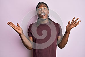 African american man with braids wearing casual clothes celebrating victory with happy smile and winner expression with raised