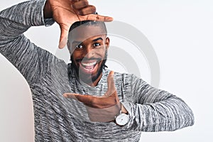 African american man with braids wearing grey sweater over isolated white background smiling making frame with hands and fingers