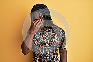African american man with braids wearing leopard animal print shirt tired rubbing nose and eyes feeling fatigue and headache