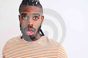 African american man with braids wearing striped t-shirt over isolated white background scared in shock with a surprise face,