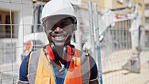 African american man builder smiling confident wearing hardhat at construction place