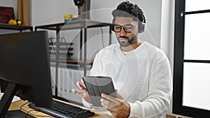 African american man business worker using touchpad and headphones working at office