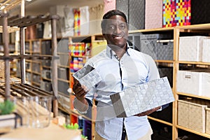 African american man chooses laundry box in store