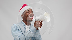 African american man in christmas hat shouts loudspeaker on sale, black friday.