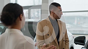 African American man customer listen woman saleswoman dealer consulting client in auto salon dealership seller buyer