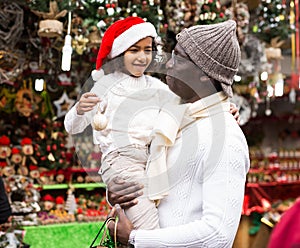 African american man with daughter in buying Christmas decoration