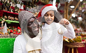 African american man with daughter in buying Christmas decoration