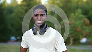 African American man demonstrates toothy smile in green park