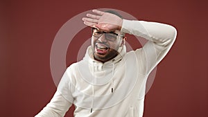 African American man desperately wiping off profuse sweat from forehead in high heat