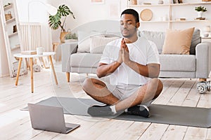 African American Man Doing Yoga Sitting At Laptop At Home