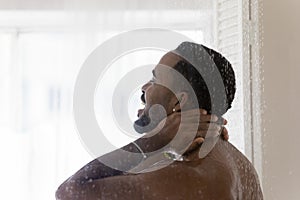 African american man enjoy taking shower in bathroom