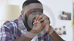 African american man folding hands in prayer, sincere faith in god, religion