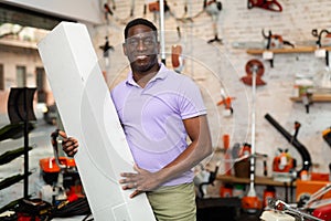 African-american man with box in gardening tools shop