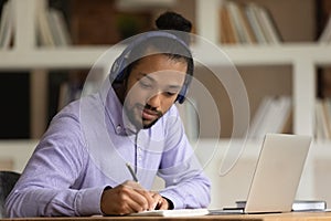 African American man in headphones study online on computer