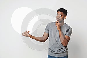 African-american man holding blank speech bubble on white