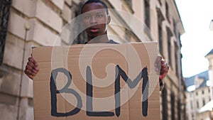 African American man holding a poster with the inscription BLM. The action of supporting the movement of black lives