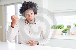 African American man at home angry and mad raising fist frustrated and furious while shouting with anger