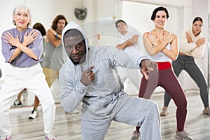 African American man learning to dance krump with group