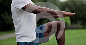 African american man limbering-up and stretching legs after running jog workout. Runner stretching and warming-up before