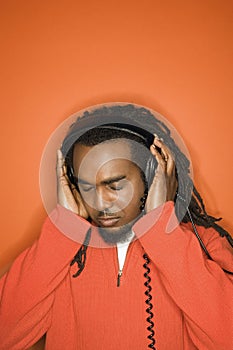 African-American man listening to headphones.