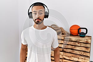 African american man listening to music using headphones at the gym depressed and worry for distress, crying angry and afraid