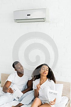 African american man looking at sweaty woman in room