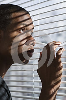 African American man looking at window, vertical