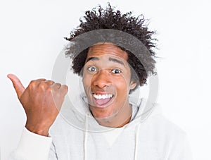 African American man over white isolated background pointing and showing with thumb up to the side with happy face smiling