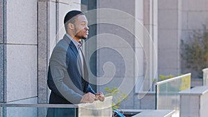 African American man pensive serious dreaming relaxed thoughtful employee taking break from work in office standing on