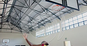 African American man playing basketball indoors, with copy space