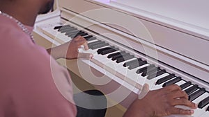 african american man playing piano, closeup of hands, musician or composer creating music