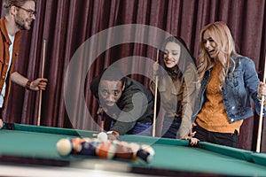 african american man playing in pool at bar