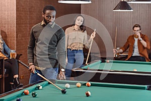 african american man playing in pool at bar