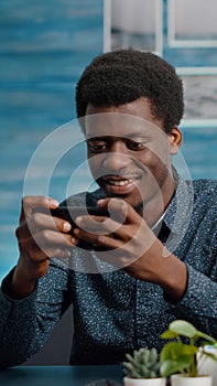 African american man playing video games on his phone