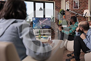 African american man playing video games on tv console