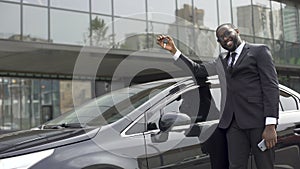 African-American man pleased that fulfilled his dream and bought luxury car