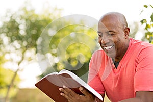 African American man praying and reading the Bible.