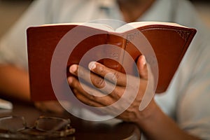 African American man praying and reading the Bible.