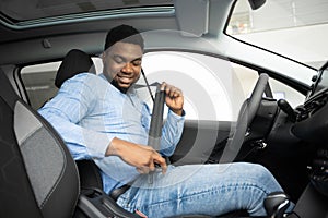 African American Man Putting On Seat Belt Sitting In Auto