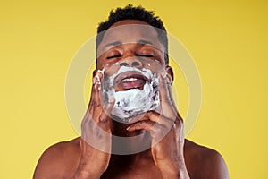 African-american man with razor and shaving foam on his face