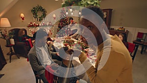 African American man records video on Christmas family dinner