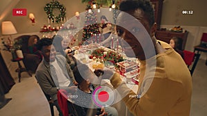 African American man records video on Christmas family dinner