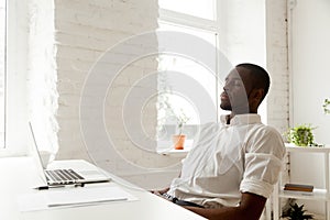 African-american man relaxing after work breathing air in home o