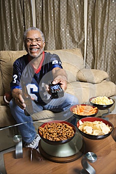 African-American man with remote pointed at viewer.