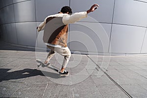 African american man rids on skateboard backwards