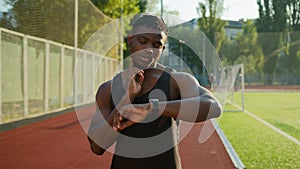 African American man runner jogger athlete muscular sportsman training outdoors athletic ethnic guy using smart band